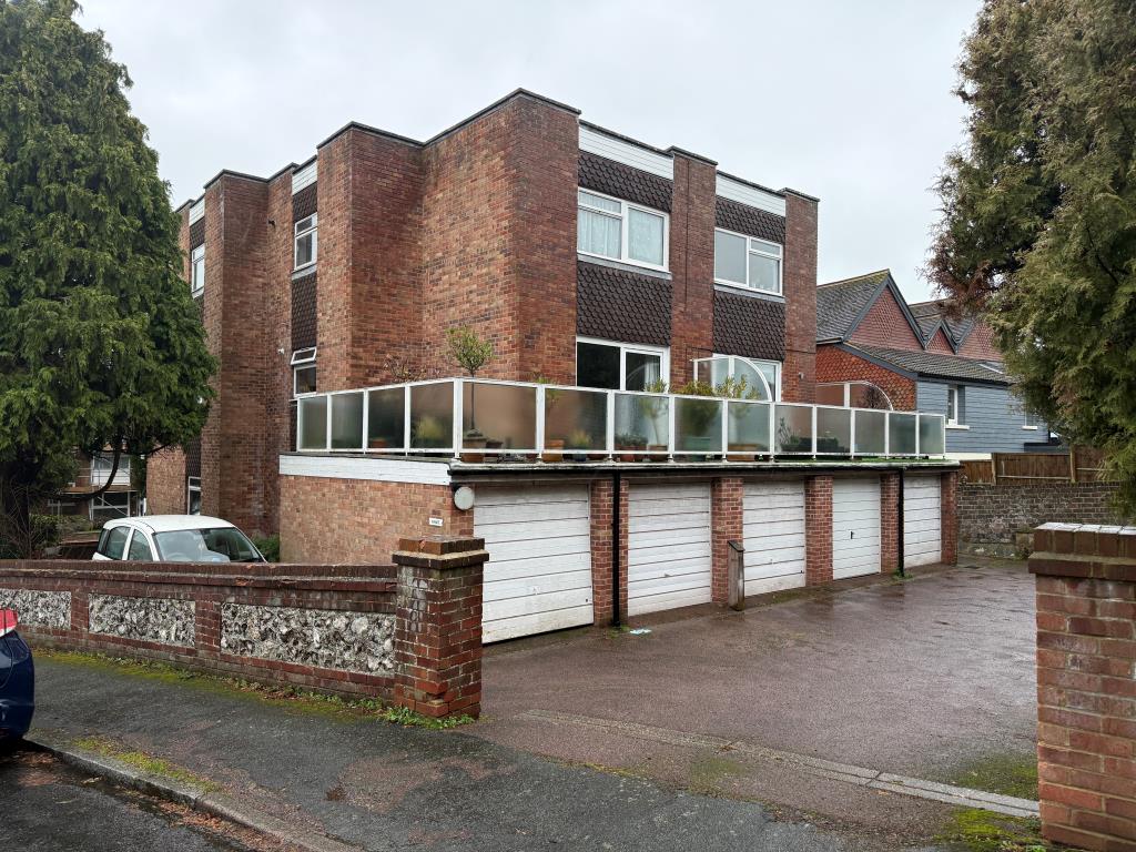 Lot: 80 - GROUND FLOOR FLAT WITH GARAGE IN NEED OF UPDATING - Rear view of block with garages from Arundel Road